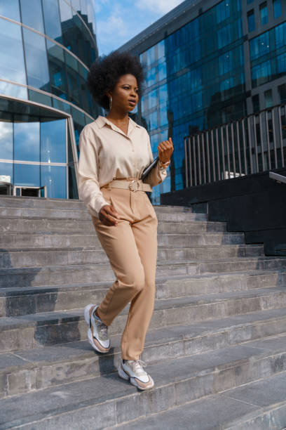 istock A serious dark skinned female office worker goes down the stairs in a lunch time 1352265062