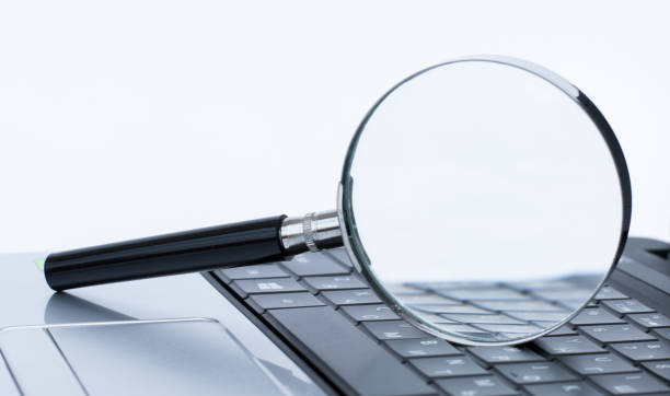 istock Magnifying glass with empty white copy space. Laptop seeking information 1352265115
