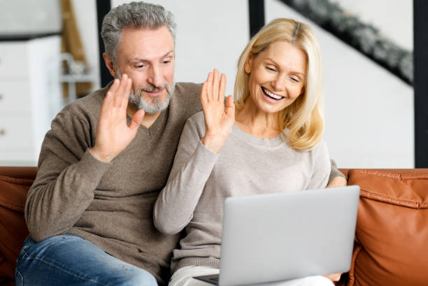 istock Cheerful spouses waving into webcam, involved virtual meeting with family 1352265264