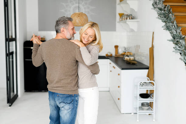 un couple romantique d’âge moyen s’amuse, danse et rit, sort avec quelqu’un - couple dâge mûr photos et images de collection