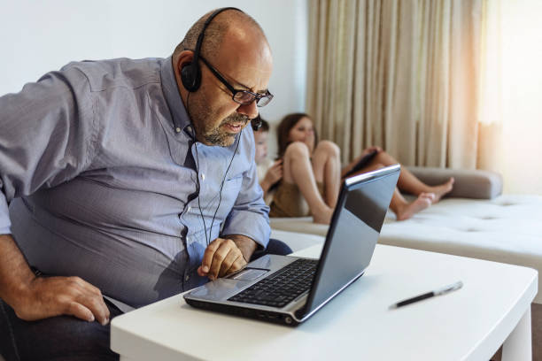 istock Happy Caucasian man using laptop and making video call while drinking coffee and working at home. 1352266670