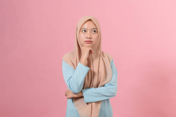 Young Asian muslim woman looking at a copy space or thinking an idea