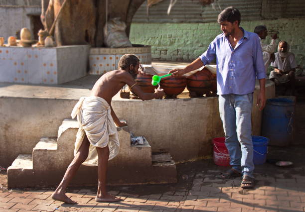 servire acqua a un uomo di casta bassa (dalit), orchha, madhya pradesh, india - casita foto e immagini stock