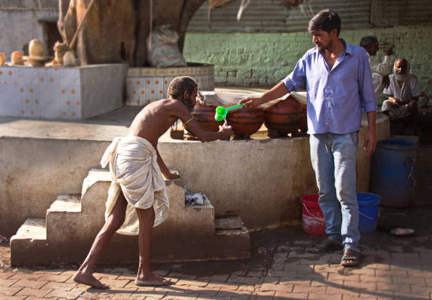 Serving water to a low caste man (dalit), Orchha, Madhya Pradesh, India stock photo
