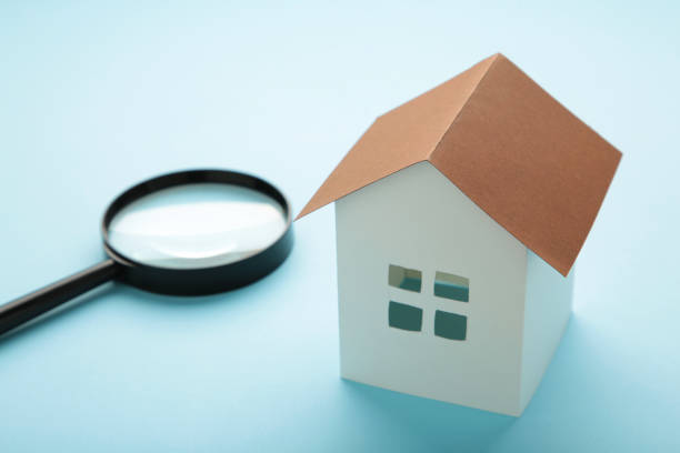 istock House model magnifying glass on blue background. Insurance concept 1352267896