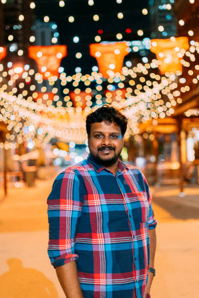 istock Portrait of a Cheerful Indian Man Standing Under Warm Tungsten-Colored String Lights on Larimer Square in Denver, Colorado at Night with Copy Space 1352271026
