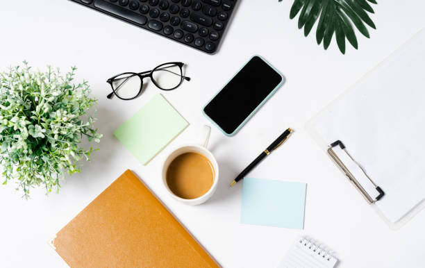 istock Top view of coffee, book, notebook, pen, keyboard, phone on white background 1352272124