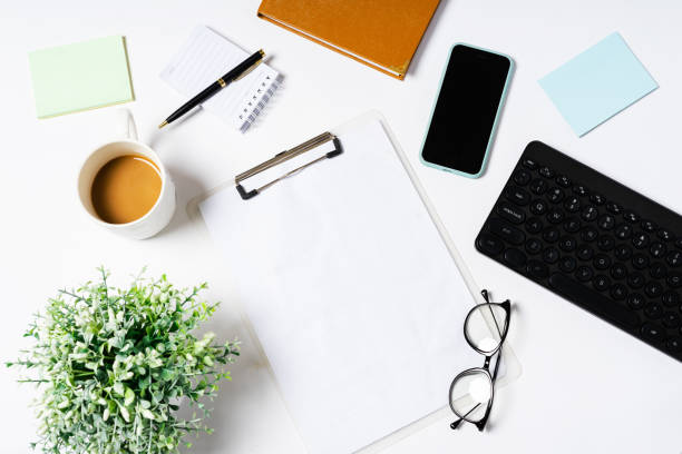 istock Top view of coffee, book, notebook, pen, keyboard, phone on white background 1352272132