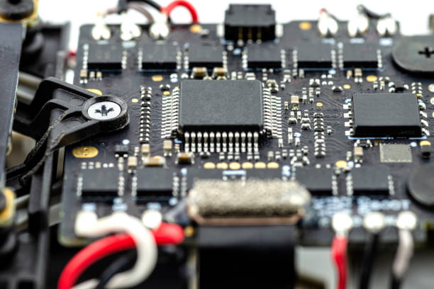 istock Macro pictures of an integrated circuit on a black PCB with a processor and semiconductors, electric cables visible. 1352272365