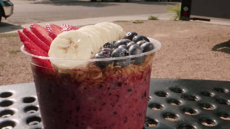 Extreme Macro Close-Up Shot of a Healthy Acai Food Bowl on a Picnic Table Outdoors in the Summer