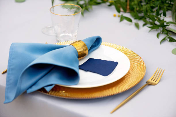 istock Elegant and chic wedding table setting in gold and blue colors and fresh flowers. Soft selective focus. 1352273253