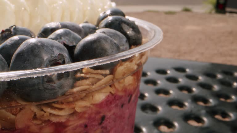 Extreme Macro Close-Up Shot of a Healthy Acai Food Bowl on a Picnic Table Outdoors in the Summer