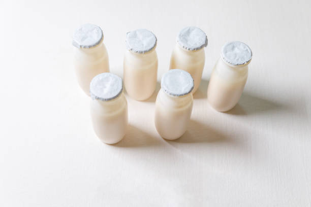 istock Small bottles with probiotics and prebiotics dairy drink on white background. Production with biologically active additives. Fermentation and diet healthy food. Bio yogurt with useful microorganisms 1352273820