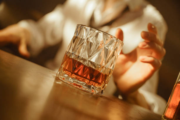 um close-up de um belo copo com uísque em uma iluminação profissional - brandy bottle alcohol studio shot - fotografias e filmes do acervo