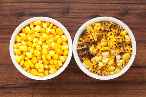 Top view of two bowls side by side with boiled and grilled corn kernels