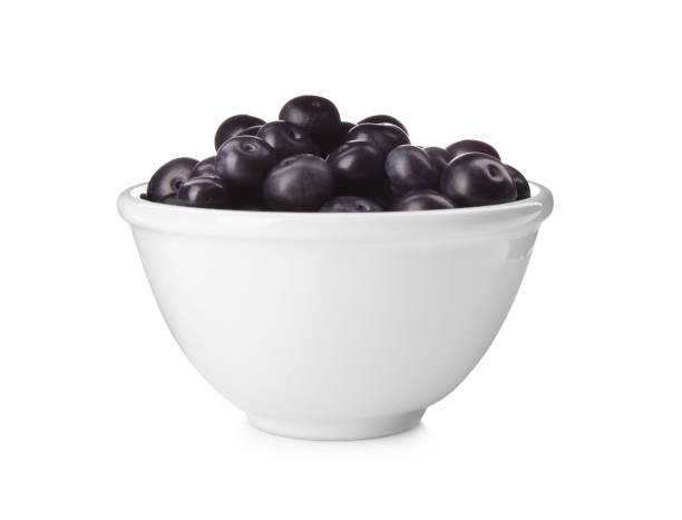 istock Fresh acai berries in bowl isolated on white 1352275722