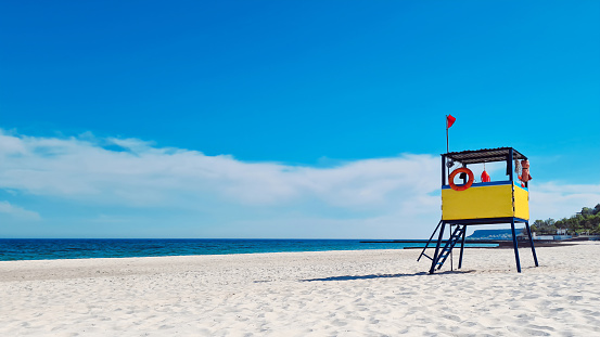 Lifeguard tower on the beach against the background of the sea and blue sky