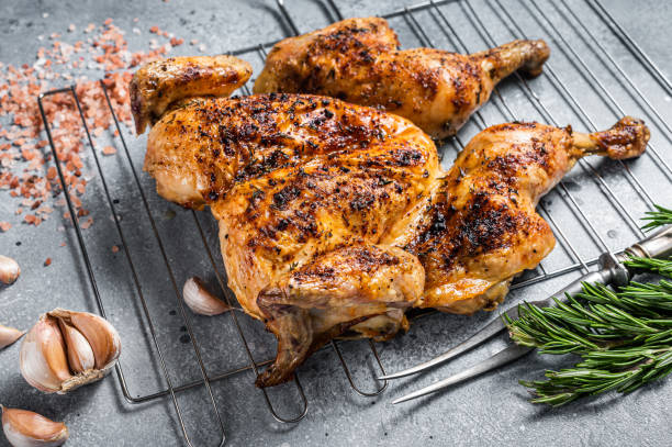 Traditional spatchcocked barbecue chicken on grill. Gray background. Top view