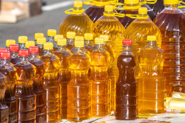 flaschen mit bio-sonnenblumen-pflanzenöl stehen während der landwirtschaftsmesse auf dem tisch - sunflower seed oil stock-fotos und bilder