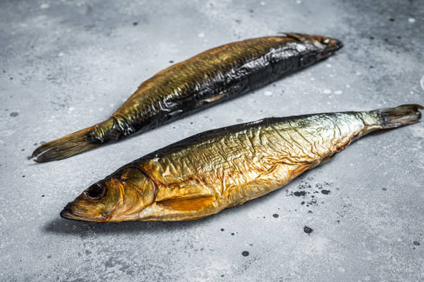 arenques enteros ahumado caliente en la mesa de la cocina. fondo gris. vista superior - pescado secado fotografías e imágenes de stock