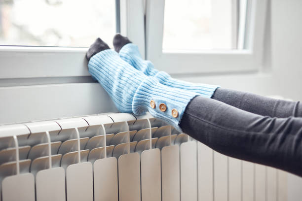 istock Woman's feet with woolen socks, enjoying inside home on the radiator. 1352279714