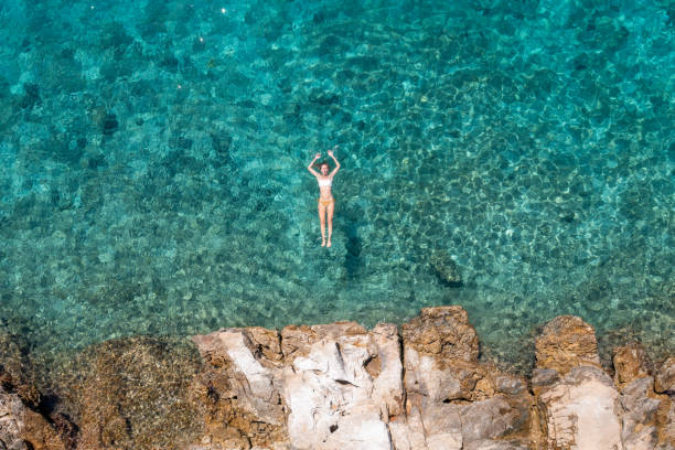istock Woman floating turquoise sea 1352280438
