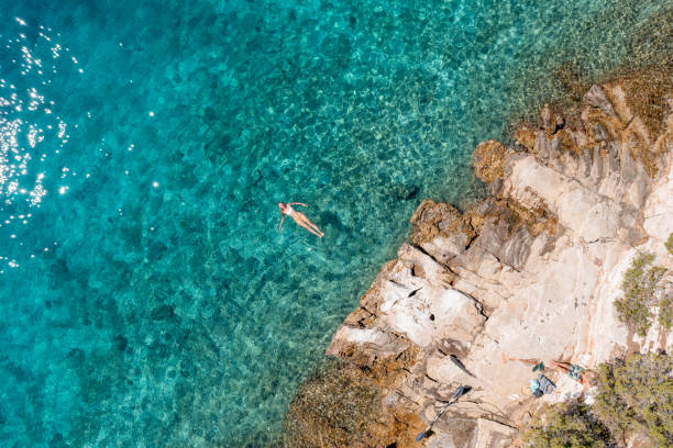istock Woman floating turquoise sea 1352280479