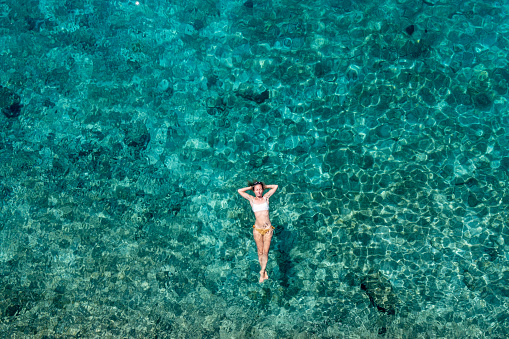 Woman floating turquoise sea