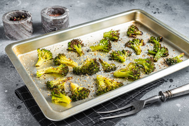 istock Roasted broccoli cabbage with garlic in baking tray. Gray background. Top view 1352280735