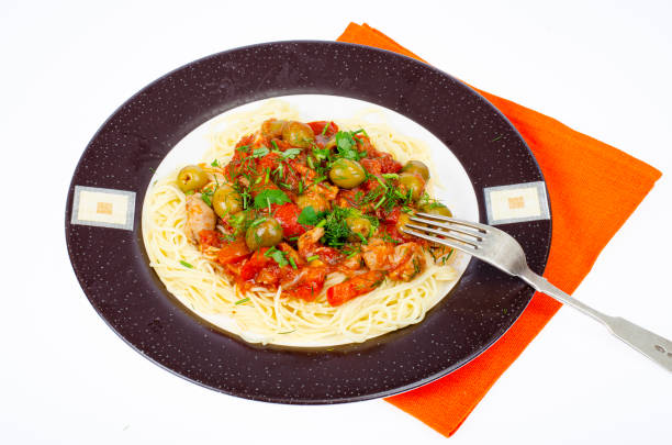 Spaghetti with stewed vegetables and green olives. Studio Photo.