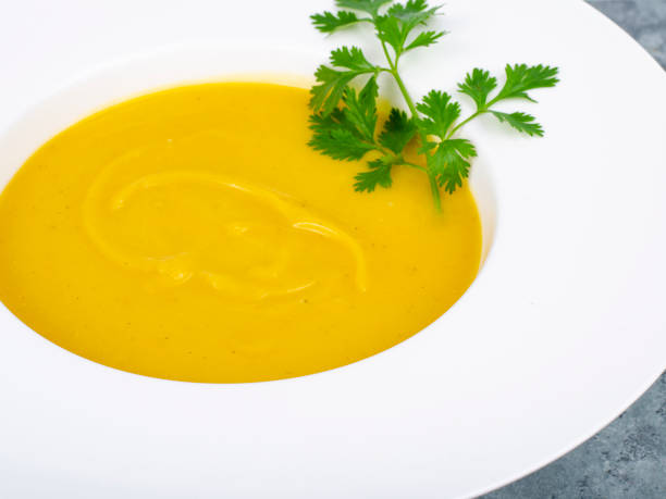 istock White plate with thick pumpkin cream soup. Studio Photo. 1352282428