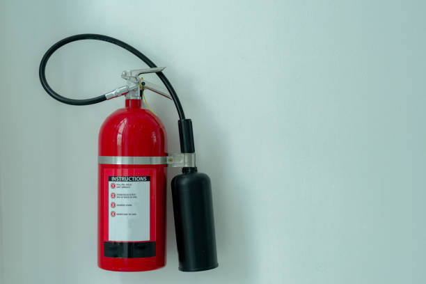istock black red fire extinguisher stuck on a white concrete wall in a house 1352285920