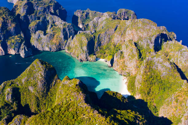 vista desde arriba, impresionante vista aérea de la bahía maya con su agua turquesa y una playa de arena blanca. ko phi phi le o ko phi phi leh es una isla del archipiélago phi phi, en el estrecho de malaca, provincia de krabi, tailandia. - phuket province beach blue cliff fotografías e imágenes de stock