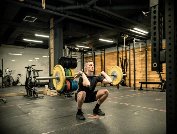 istock Young Man lifting weights in the Gym 1352287554
