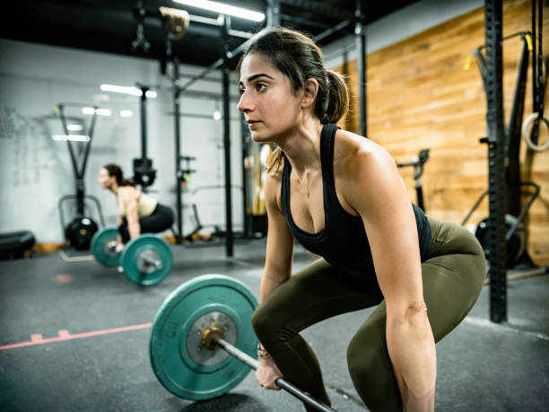 istock Young woman lifting weights in the Gym 1352287848