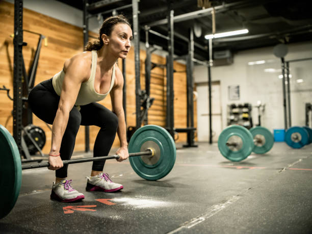 istock Young woman lifting weights in the Gym 1352288201