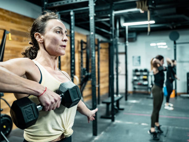 istock Young woman lifting weights in the Gym 1352289077