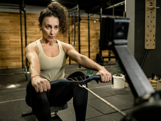 istock Woman exercising on rowing machine in the Gym 1352289224