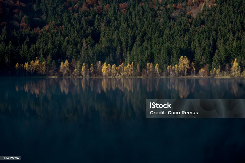 Autumn landscape with trees reflecting in the water at St. Ana's lake, Romania 2021 Stock Photo
