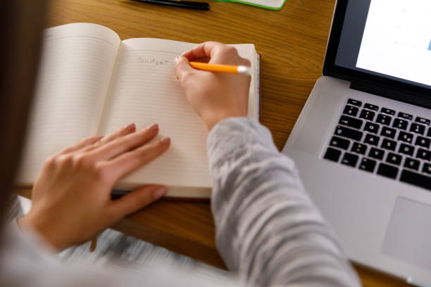 istock Businesswoman writing down a budget plan for a project she is working on 1352292540