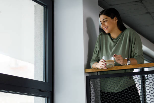 istock Young businesswoman on a coffee break looking through the window 1352292904