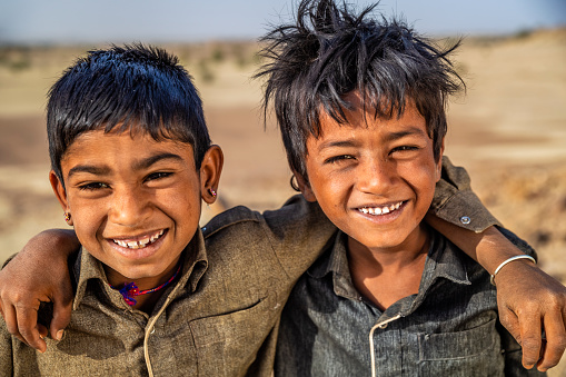 Indian young boys resting on a sand dune - desert village, Thar Desert, Rajasthan, India.