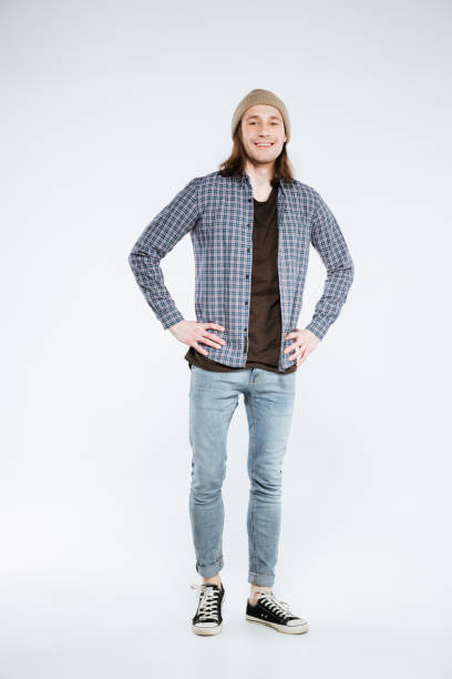 istock Vertical image of Smiling hipster with arms on hip 1352295867