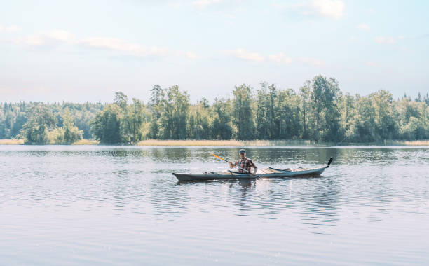 istock Young man floats on a boat on the river. 1352295943