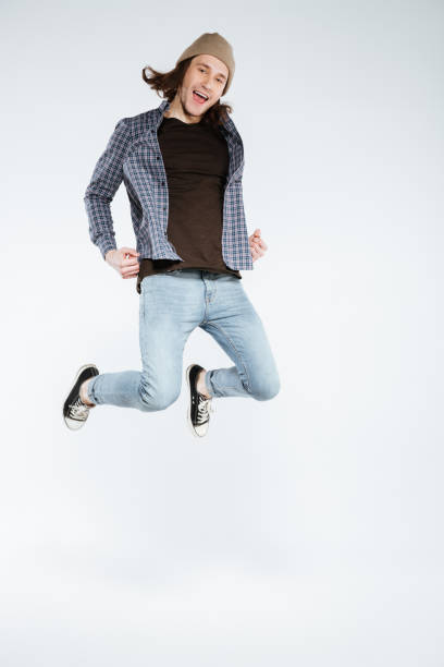 istock Vertical image of hipster jumping in studio 1352296555