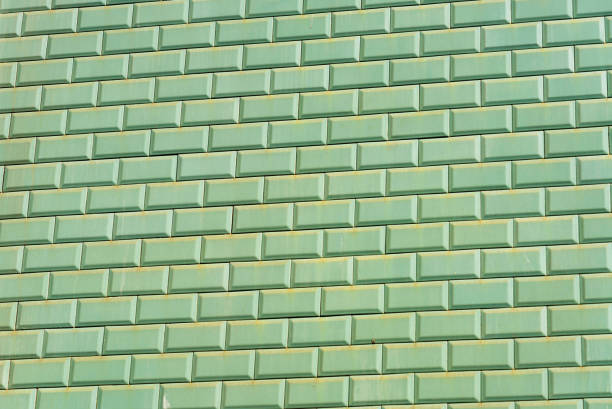An exterior wall of plain green tiles.