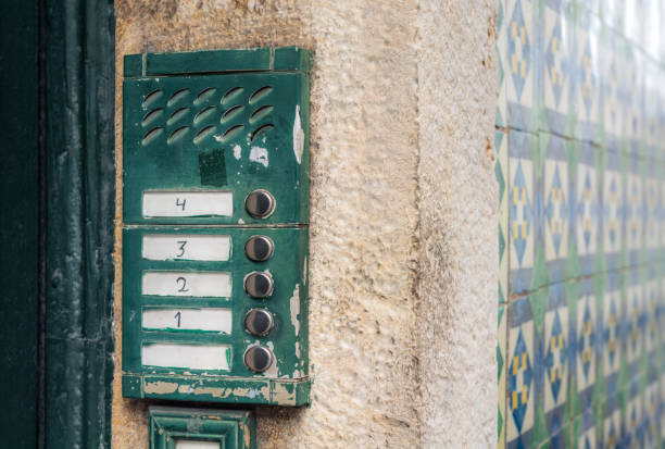 Traditional apartment intercom in Portugal Buzzers for flats at each level outside the entrance to an old fashioned apartment building in Lisbon, Portugal, with traditional tiles making up the exterior finish of the building. doorbell photos stock pictures, royalty-free photos & images