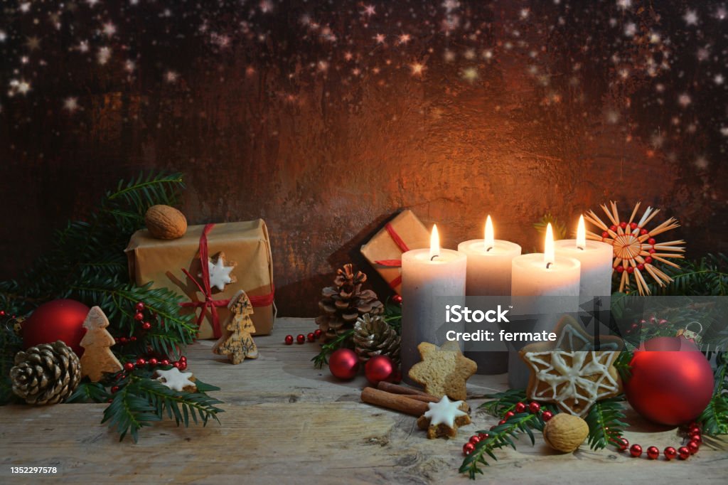 Fourth Advent, four candles are lighted, Christmas decoration and gifts on rustic wooden planks against a dark brown background with copy space, selected focus Fourth Advent, four candles are lighted, Christmas decoration and gifts on rustic wooden planks against a dark brown background with copy space, selected focus, narrow depth of field Christmas Stock Photo