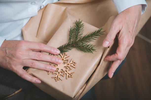istock old women's hands, christmas gift packaging, fir, snowflake 1352298552