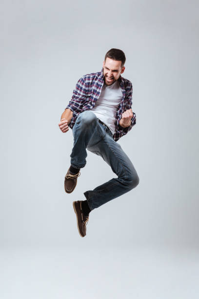 istock Vertical image of Bearded man in shirt which jumping 1352298592